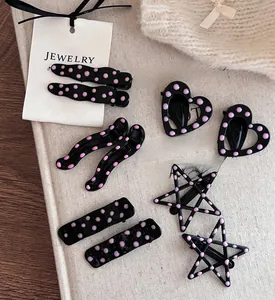 Gros plan détaillé de barrettes à pois roses de formes variées sur fond texturé