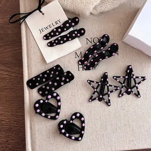Détail de pinces à cheveux à pois roses en forme de cœur, d'étoile et de vagues