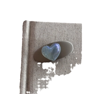 Sweet silver ribbon hair clip with holographic heart charm on a brown base