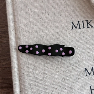 Barrette à cheveux noire à pois roses avec design ondulé pour un style chic et moderne