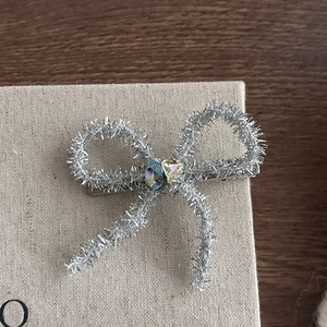 Elegante zilveren haarklem met glitterstrik en hartvormige blauwe en gele kristallen