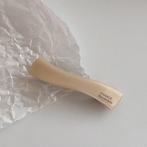 Détail de la pince à cheveux ondulée en acétate avec texte France Handmade et fini lisse