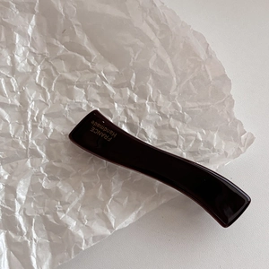 Détail de la pince à cheveux en acétate marron avec logo doré FRANCE Handmade