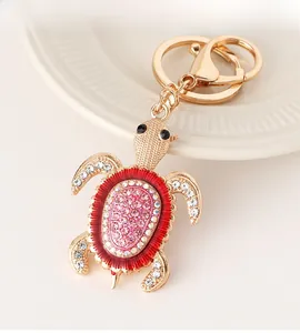 Détail du porte-clés tortue en métal doré avec strass roses et fermoir mousqueton