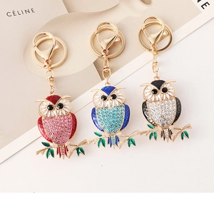 Detailed close-up of owl keychains with colorful rhinestones and gold lobster clasp