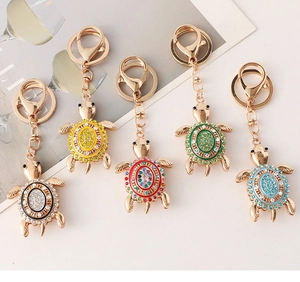 Detailed close-up view of colorful rhinestone-encrusted turtle keychains in gold finish
