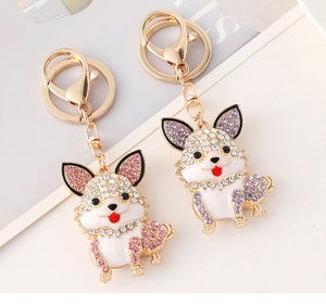 Detailed macro view of pink and purple dog keychains with rhinestones and gold finish