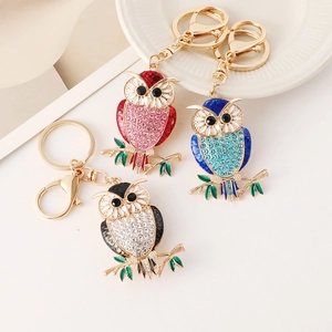 Three colorful crystal owl keychains with rhinestone embellishments on gold metal rings