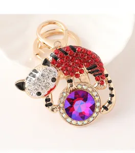 Vue détaillée d'un porte-clés tigre doré avec strass rouges et une grande gemme violette