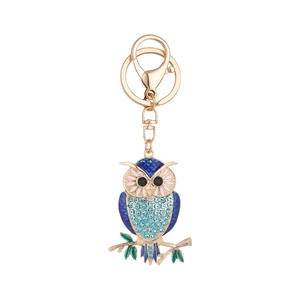 Golden owl keychain with blue crystals and enamel detail on a white background