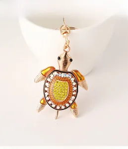 Détail de porte-clés tortue serti de cristaux avec des membres en émail orange