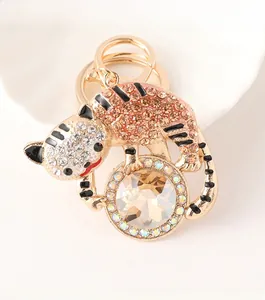 Gros plan du porte-clés tigre doré orné de strass et cristal sur un plateau blanc élégant