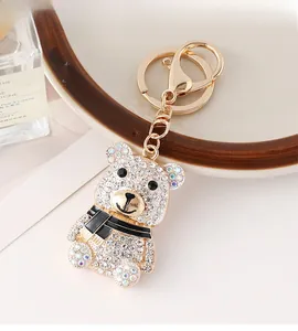 Détail d'un porte-clés ours doré orné de strass brillants et d'une écharpe élégante