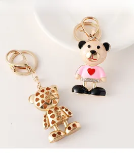 Detail showing creative bear keychains in gold metal and pink enamel heart outfits