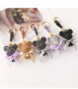 Detailed arrangement of five rhinestone bear keychains with satin bows and alphabet charms