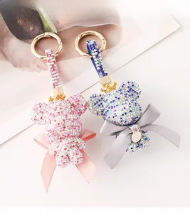 Detailed macro of pink and blue rhinestone bear keychains with gold crown and letter C charm