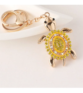Detail of creative turtle keychain with yellow rhinestones on a gold alloy shell