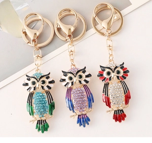 Detailed view of colorful rhinestone owl keychains in three vibrant enamel finishes