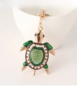 Détail du porte-clés tortue verte avec strass brillants et finition en métal doré