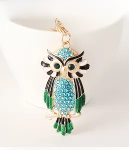 Detailed close-up of a colorful rhinestone owl keychain with blue crystals and green enamel