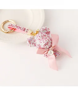 Detailed macro of pink rhinestone bear keychain with gold crown and B letter charm