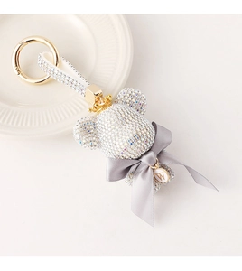 Detail of crystal bear keychain with leather strap, gold crown and initial W pendant