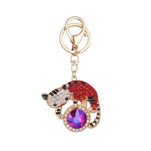 Porte-clés chat scintillant avec strass rouges et blancs tenant un cristal violet