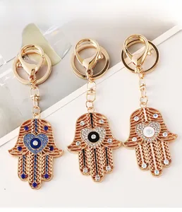 Trois porte-clés main de Hamsa avec œil protecteur en émail bleu, noir et blanc et cristaux