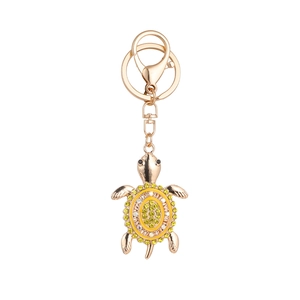 Charming rose gold turtle keychain with yellow and white rhinestones on white background