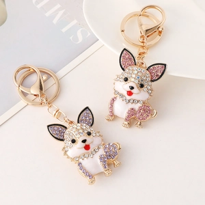 Cute enamel dog keychains with rhinestones in pink and purple colors on a white plate