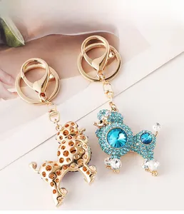 Detail showing front and back of gold-tone poodle keychain with blue rhinestones