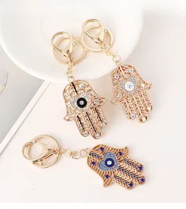 Détail de trois porte-clés main de Fatma avec cœurs œil bleu et cristaux incrustés