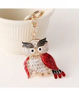 Détail d'un porte-clés chouette avec strass brillants et émail rouge sur base métal