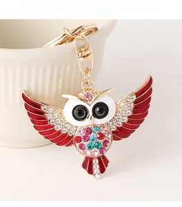 Détail du porte-clés hibou avec strass colorés et ailes en émail rouge vif