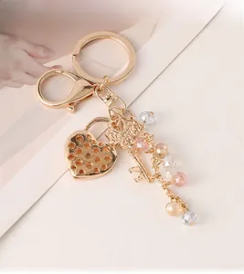 Detail of heart lock keychain with gold metal plating, tiny key and colorful crystal beads