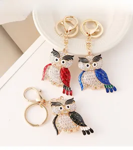 Gros plan de porte-clés hibou en strass rouge, bleu et noir avec placage en or