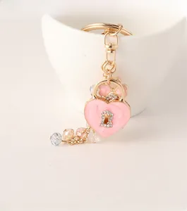 Detail showing a golden heart lock keychain with pink enamel and sparkling rhinestones