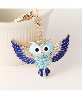Détail du porte-clés hibou avec ailes en émail bleu et strass brillants sur métal doré