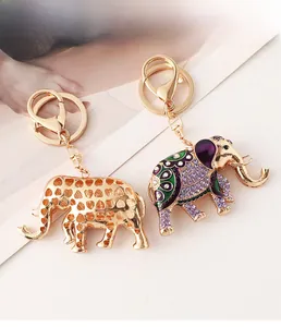 Vue détaillée du porte-clés éléphant évidé doré et du pendentif éléphant en émail serti