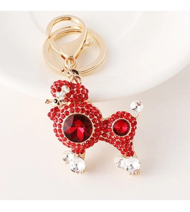 Detailed macro view of a gold-plated poodle keychain with sparkling red rhinestones