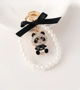 Detail of panda pearl keychain with crystal rhinestones and a black ribbon bow charm