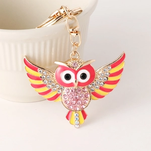 Porte-clés chouette avec base en métal doré, strass roses et ailes rouges vives