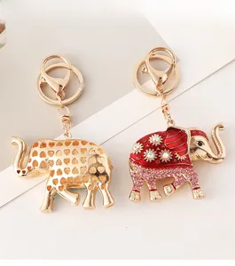 Detail of golden elephant keychains with heart cutouts and red enamel diamond inlay