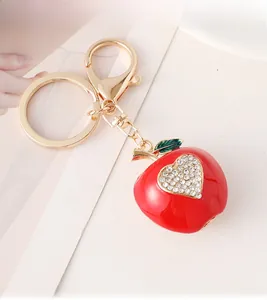 Détail d'un porte-clés pomme rouge avec strass en forme de cœur et fermoir doré brillant