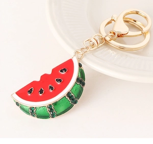 Close-up of a sparkling watermelon keychain with red and green crystals and golden clasp