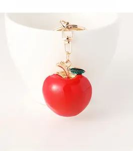 Détail d'un porte-clés pomme rouge avec strass en cœur et mousqueton doré brillant