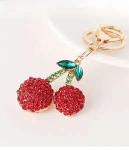 Detail of red rhinestone cherry keychain with golden lobster clasp and sparkling crystals