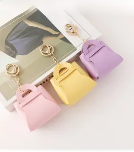 Detailed view of candy-colored faux leather mini bag keychains in pink, yellow and purple