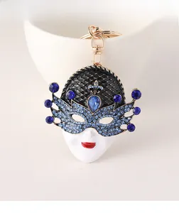 Close-up of a Venetian mask keychain with blue rhinestones and gold metal clasp