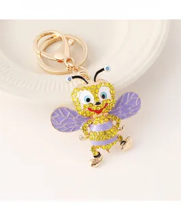 Close-up of cute cartoon bee keychain featuring yellow rhinestones and purple painted wings